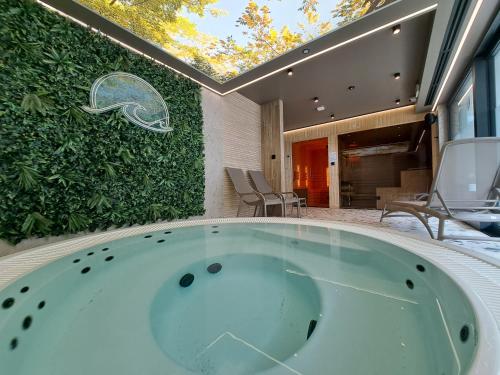 a bath tub sitting in front of a green wall at Apartament Słoneczny & SPA Plażowa A208 in Grzybowo