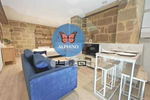 a living room with a blue couch and a butterfly sign at Le One, cosy et authentique in Brive-la-Gaillarde