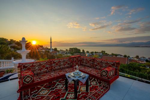 a balcony with a table and the sunset in the background at Vila Sela in Shkodër