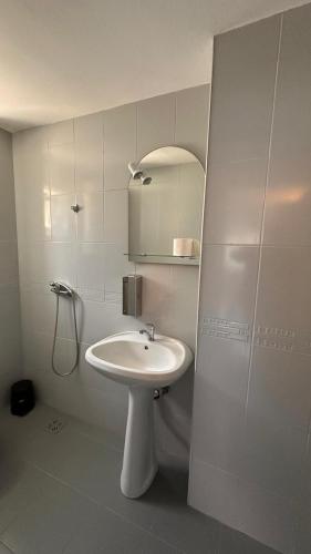 a white bathroom with a sink and a mirror at Forest house in Eforie Nord
