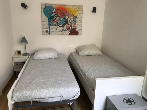 une chambre avec deux lits et un tableau au mur dans l'établissement Charmante maison, à Saint-Cyr-sur-Mer