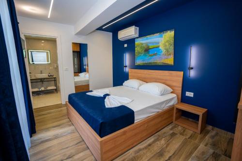 a bedroom with a bed with a blue wall at Vila Sela in Shkodër