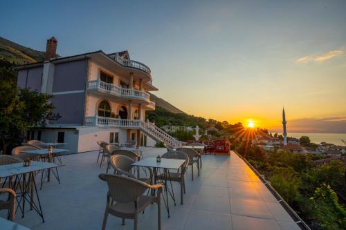 a restaurant with tables and chairs at sunset at Vila Sela in Shkodër