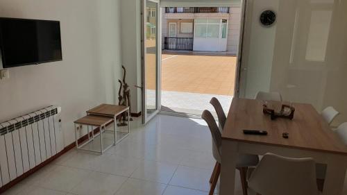 a dining room with a table and chairs and a television at Arenales Azules in Baiona