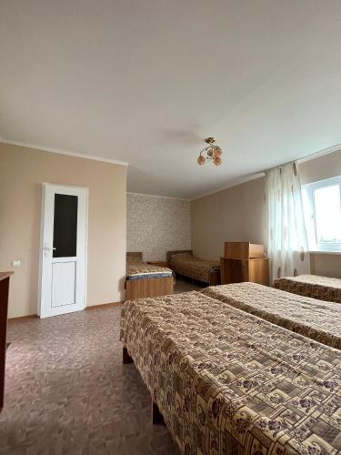 a hotel room with two beds and a window at Отель на берегу in Bosteri