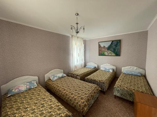 a group of four beds in a room at Отель на берегу in Bosteri