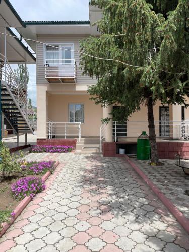 a house with a tree in front of it at Отель на берегу in Bosteri