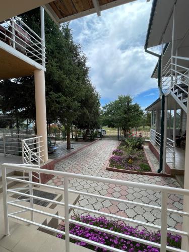 a white fence in front of a building with flowers at Отель на берегу in Bosteri