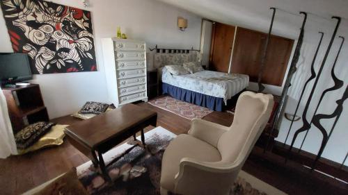 a living room with a bed and a table and a chair at Il Casale Del Sogno in Ardea