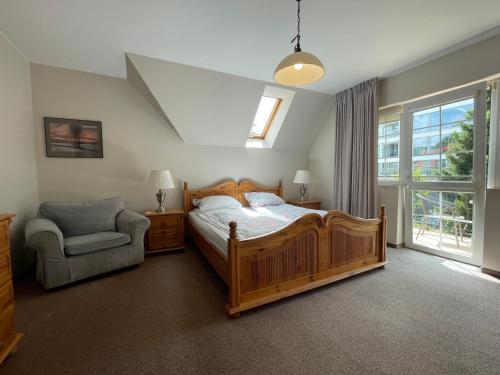 una camera da letto con un letto, una sedia e una finestra di Dom Przy Plaży a Mielno