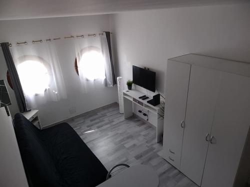 un salon avec un canapé et une télévision dans l'établissement Studio Les pieds dans l'eau, à Mandelieu-la-Napoule