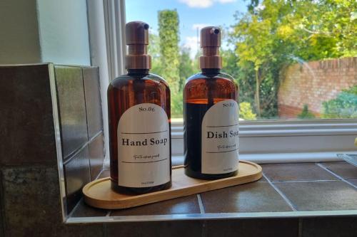 two bottles of wine sitting on a counter next to a window at Windsor property near Legoland with free parking in Windsor