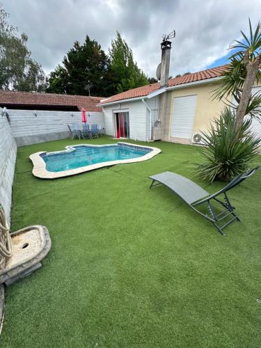 une cour avec une piscine, une chaise et une maison dans l'établissement Maison familiale avec piscine, à Mimizan
