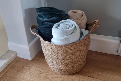 a basket filled with towels sitting on the floor at Windsor property near Legoland with free parking in Windsor