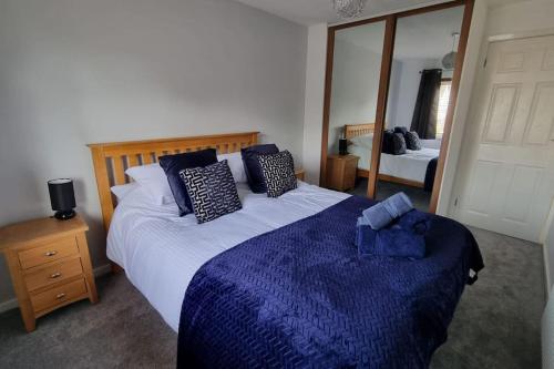 a bedroom with a large bed and a large mirror at Windsor property near Legoland with free parking in Windsor