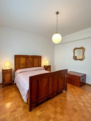 a bedroom with a bed and two tables and a mirror at La Casa dei Nonni in Alano di Piave
