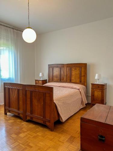 a bedroom with a large wooden bed and a table at La Casa dei Nonni in Alano di Piave