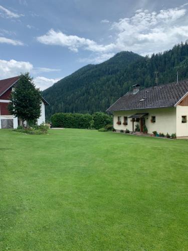 a large green yard with a house and a building at Ferienwohnung Familie Kampl in Frauenstein