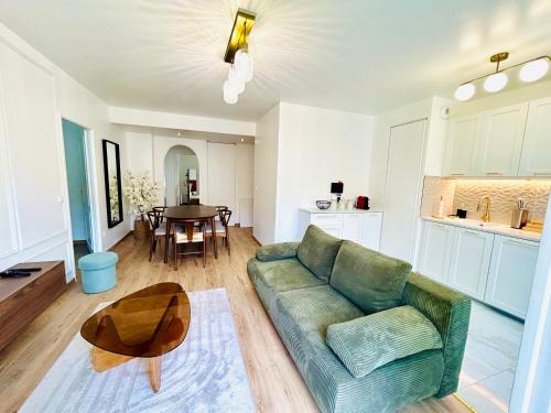 un salon avec un canapé vert et une table dans l'établissement Serenity Place, à Serris