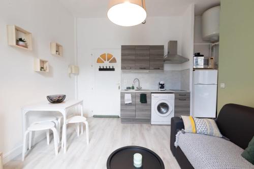 un salon avec un canapé et une table et une cuisine dans l'établissement Le 107 CARCA !, à Carcassonne