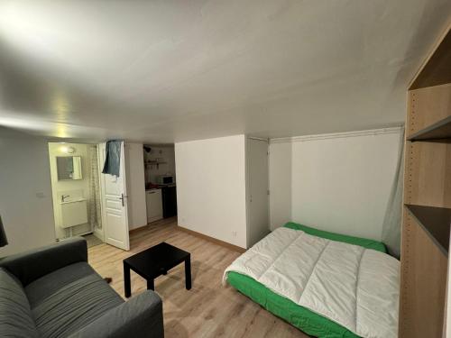 une petite chambre avec un lit et un canapé dans l'établissement Stade de France Appartement, à Saint-Denis
