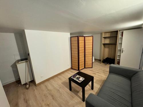 un salon avec un canapé et une table dans l'établissement Stade de France Appartement, à Saint-Denis