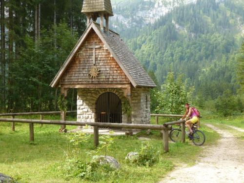 a man riding a bike next to a small building at FreiRaum in Ofterschwang
