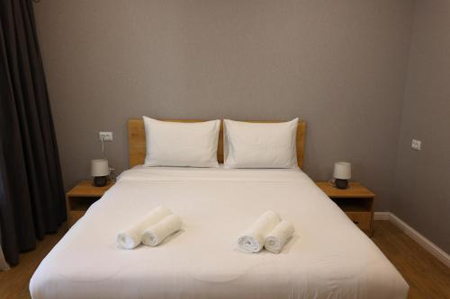 a white bed with two rolled towels on it at Greenwood in Borjomi