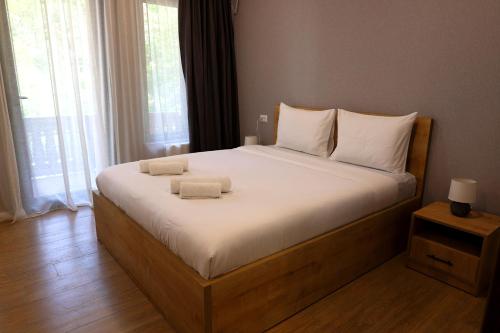 a bedroom with a large bed with two towels on it at Greenwood in Borjomi