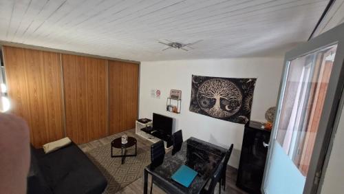 un salon avec un canapé et une télévision dans l'établissement Le repaire d'Odin - au coeur du centre ville, à Saint-Claude