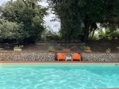 two orange chairs sitting next to a swimming pool at Little Umbria Guest House in Ficulle