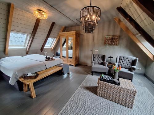 a bedroom with a bed and two chairs in a room at B&B De Meidoornhof in Ruinen