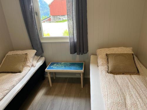 una piccola stanza con due letti e una finestra di Tunold Gård - Olahuset a Oppstryn