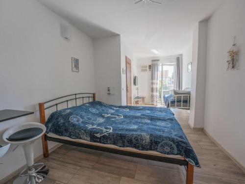 a bedroom with a bed with a blue comforter at Apartmani Maria - Studio 2 in Vantačići