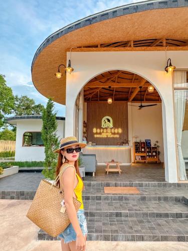 a woman in a hat standing in front of a building at SaroRach pool villa resort Kohlarn in Ko Larn