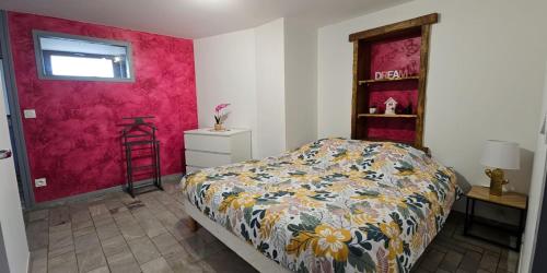 a bedroom with a bed and a red wall at Calme et cosy in Planaise