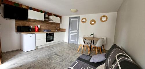 une petite cuisine et salle à manger avec une table et des chaises dans l'établissement Calme et cosy, à Planaise