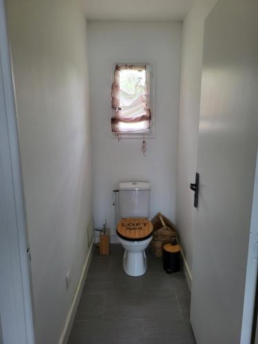 La salle de bains est pourvue de toilettes et d'une fenêtre. dans l'établissement gitechezpetitjean, à Turretot
