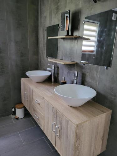 une salle de bain avec deux lavabos et un grand miroir dans l'établissement gitechezpetitjean, à Turretot