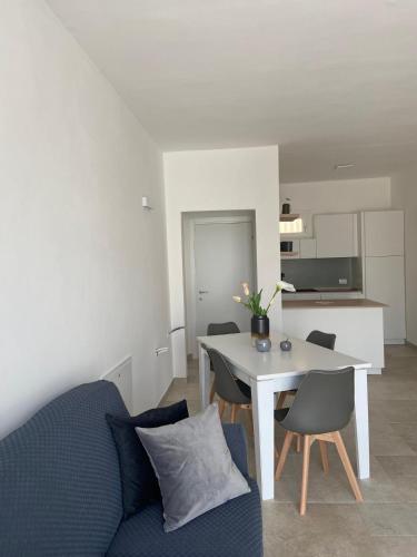 a living room with a table and a blue couch at Country House in Torre San Giovanni Ugento