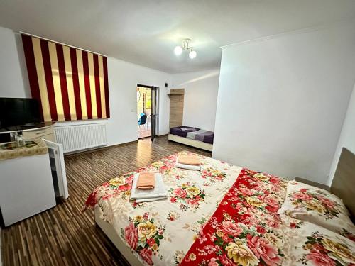 a bedroom with a bed with a red and white blanket at Pensiunea Bianca in Corbu