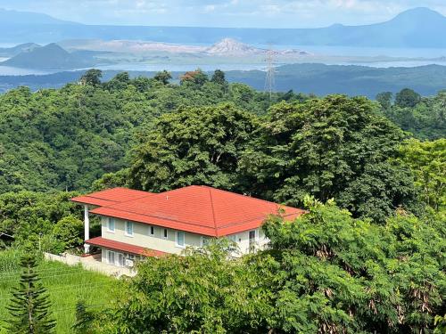 a house with a red roof in the forest at Splendido Tagaytay Taal Lake Staycation Free Parking Netflix No Free Pool in Tagaytay