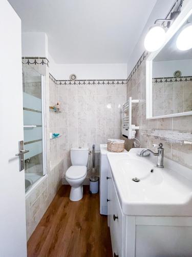 une salle de bain blanche avec des toilettes et un lavabo dans l'établissement Le Naïs - Proche centre - Parking - Wifi, à Cassis
