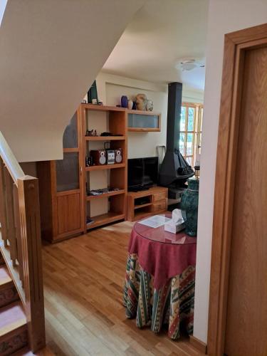 a living room with a table and a tv at Dúplex de muntanya en zona verda a Escaló in Escaló
