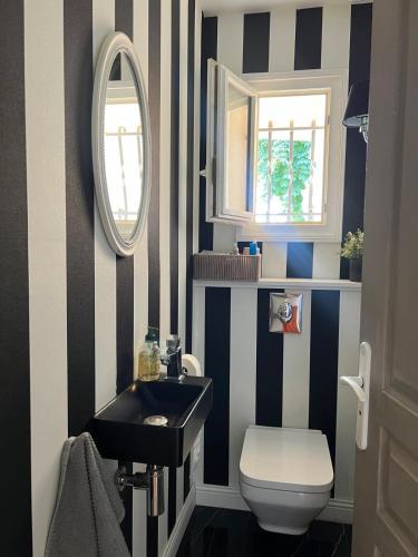 La salle de bains est pourvue d'un mur rayé noir et blanc. dans l'établissement Maison contemporaine près de la mer, à Soubise