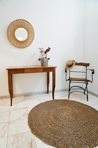 a room with a table and a mirror and a rug at Dimora Miranda in Agios Prokopios