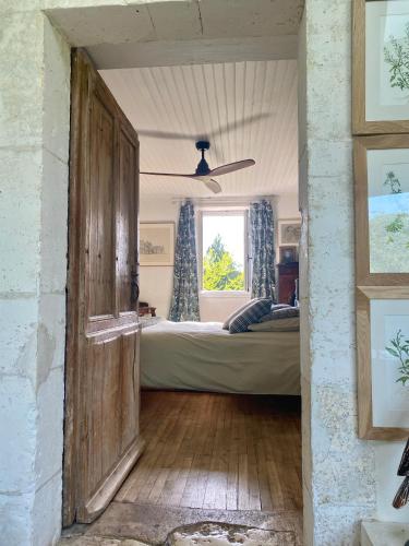 - une chambre avec un lit, une fenêtre et une porte dans l'établissement la Roussarie en Périgord, à Champagnac-de-Bélair