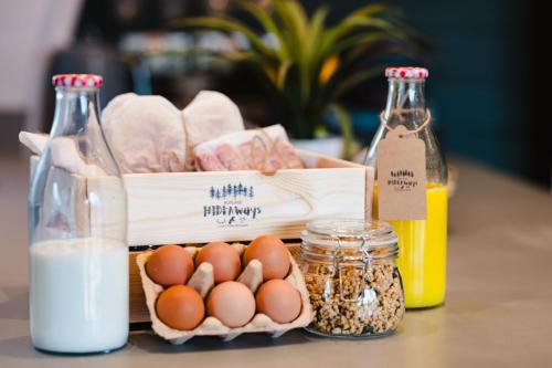a basket of eggs and bread and bottles of milk at Kite Lodge in Little Bytham