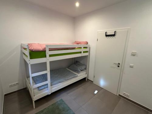 a small room with two bunk beds and a door at Ferienwohnung Ottenhof in Verden