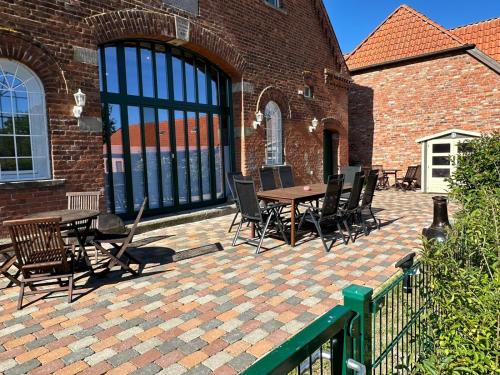 a patio with a table and chairs and a brick building at Ferienwohnung Ottenhof in Verden